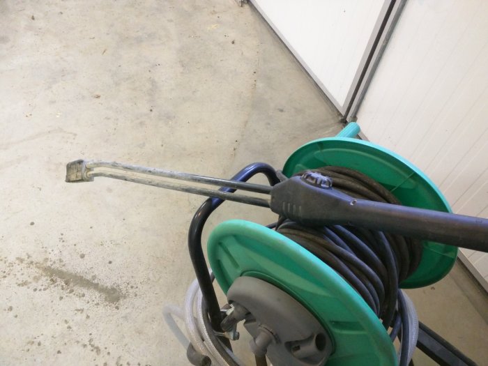 En högtryckstvätt av märket KEW 4403 med tillhörande slangupprullare och munstycke i en garage-miljö.