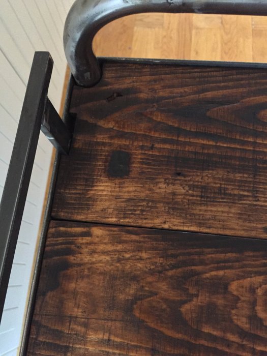Detalj av en nyligen byggd eller renoverad drinkvagn med en träyta och metallhandtag.