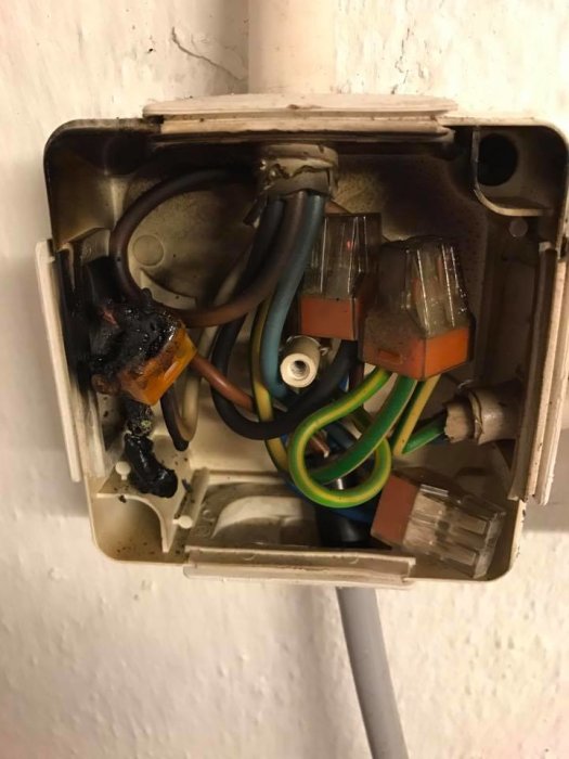 Öppen eldosa med bränt Wago-klämma och SKX-kabel, felaktig elektrisk installation.