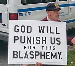 Person håller upp en skylt med texten "GOD WILL PUNISH US FOR THIS BLASPHEMY".