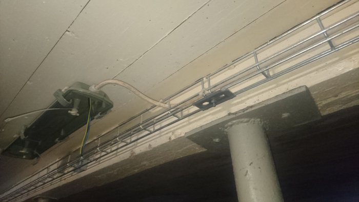 Installationsarbete i stall med kabelstegar, eluttag och öppna kablar under tak.