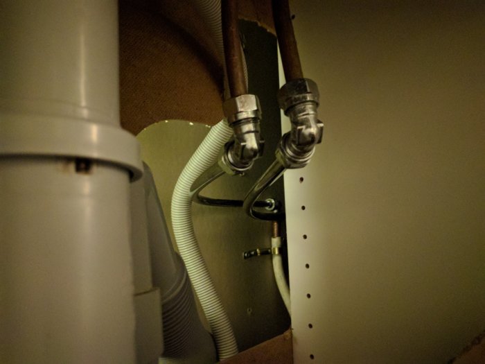 Vattenanslutningar under diskbänk med PEX-slangar, klämringskopplingar och ballofixventil.