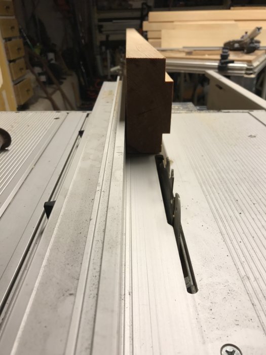 Träbit med fals i verkstad, färdigbearbetad för montering i fönsterkarm, på en bordssåg.