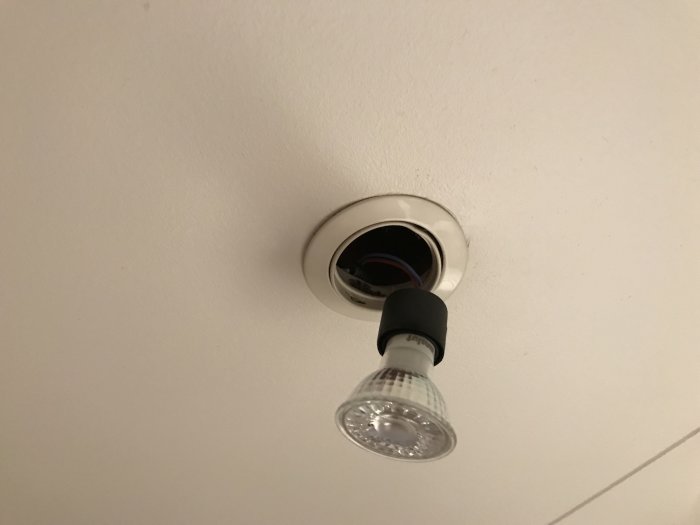 GU10 bajonettfattning utan lamphus med en metallring och en spröd, delvis sönderbruten sockel.
