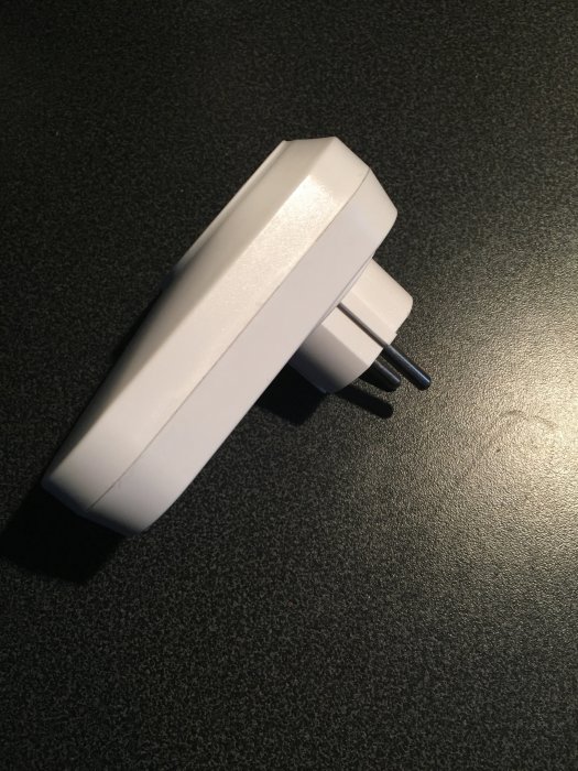 Sonoff S20 smart plug på en mörk bakgrund som visar dess byggkvalitet.