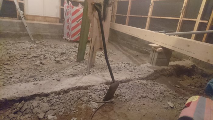 En rivningshammare (hilti te 1000 avr) ligger på ett rivet betonggolv i ett hus under renovering.