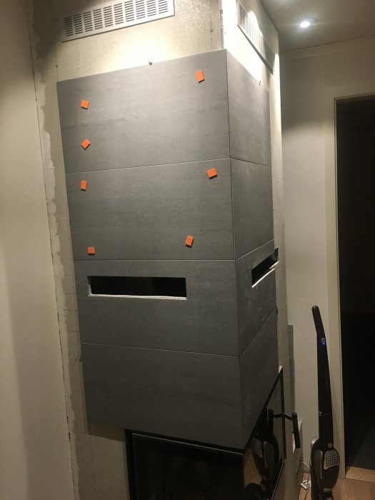 Använt granitplattor med utsågade hål som monteras runt en spis, fastsatt med orange tejp under installation.