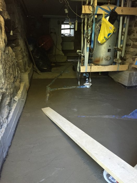 Källarrenovering med nygjutna armerade stödmurar och nylagt betonggolv i äldre hus.