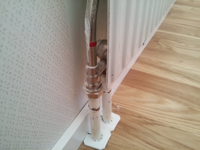 Radiator med tillhörande rör som inte blir varm trots att andra element blir det.