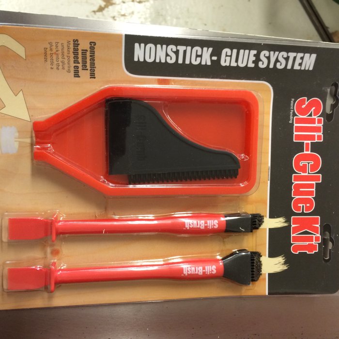 Sil-Glue Kit, ett icke-klibbigt limsystem i rött och svart, inklusive spatel och borstar.