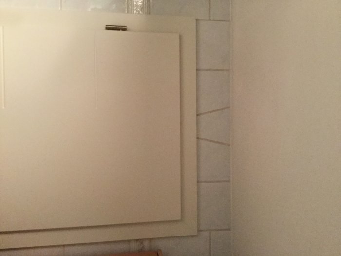 Vägg med snygg skärning mellan dörr och kaklade plattor i ett byggprojekt.