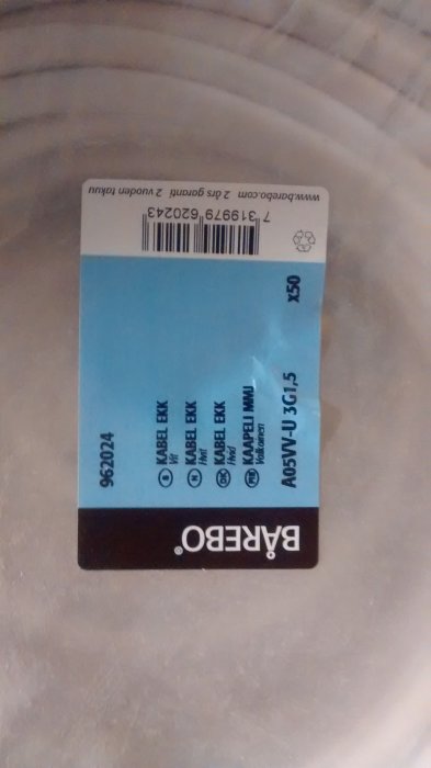 Etikett för EKK kabel 3G1,5 liggande på en yta med texten upp och ner.