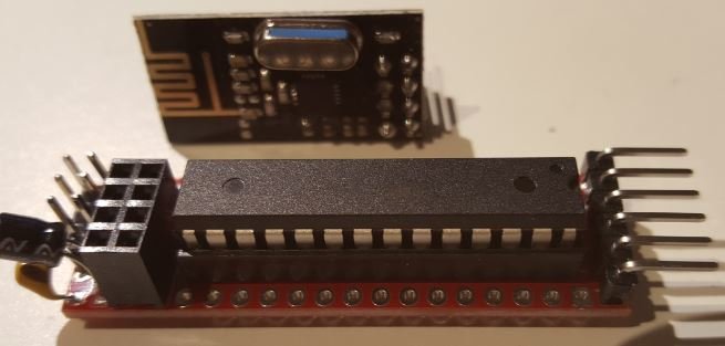 En atmega328 mikrokontroller monterad på en PCB med kondensatorer, motstånd och en trådlös modul i bakgrunden.