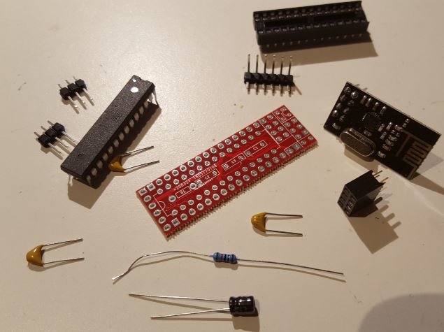 Elektronikkomponenter för PCB-projekt inklusive en Atmega328p mikrokontroller och kondensatorer på ett bord.