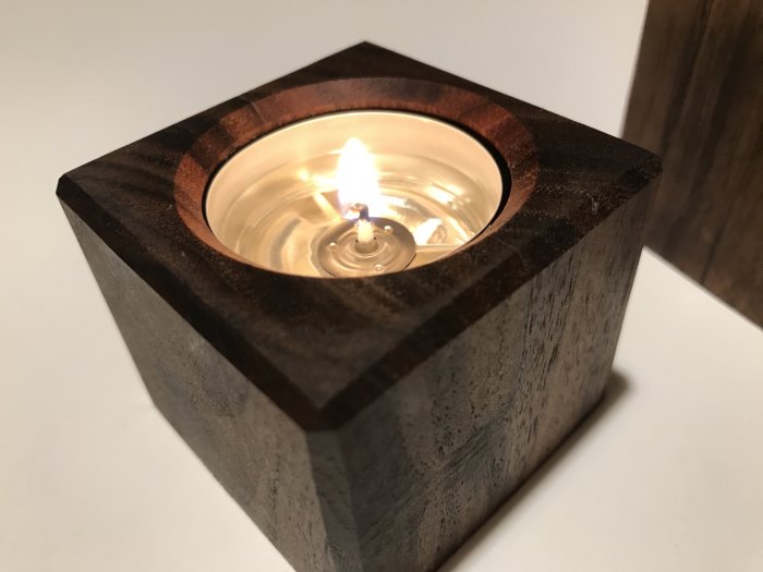 Hemmagjord värmeljushållare i valnötsträ med tändt ljus, oljad med mineralolja.