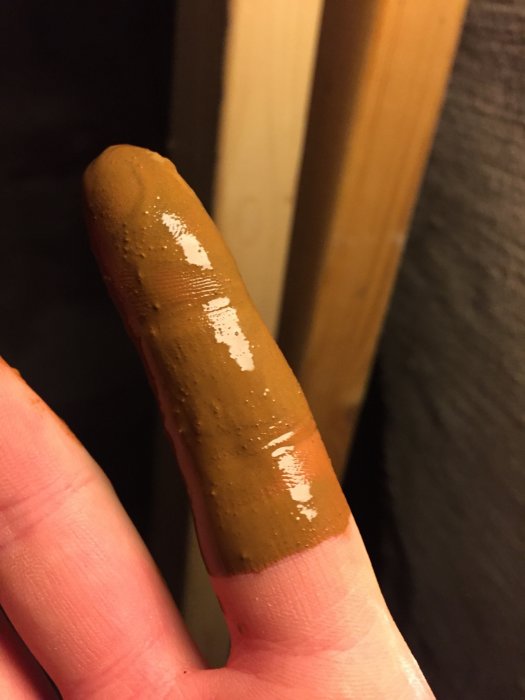 Finger med rödaktigt, lera-liknande ämne som hittades i vattenfiltreringssystemet.