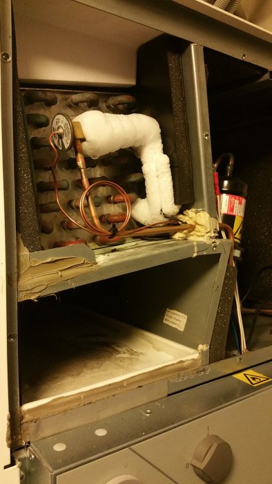Isbildning runt förångaren i en Nibe310P värmepump, synligt vid öppen servicepanel.