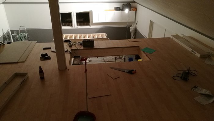 Nyinstallerat golv och trappa i ett loft, verktyg och byggmaterial synliga, väggar ska målas industrigrå.