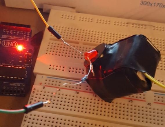 Arduino UNO ansluten till en brödplatta med olika ledningar, sensorer och en LED för debugging.