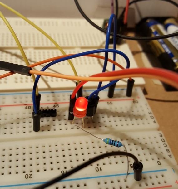 Elektronisk krets på kopplingsbräda med lysdiod, transistorer och motstånd för elsensorprojekt.