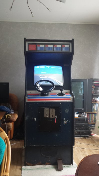 Atari Pole Position arkadspel i ett hemmiljö med ratten synlig på skärmen som visar 'GAME OVER'.