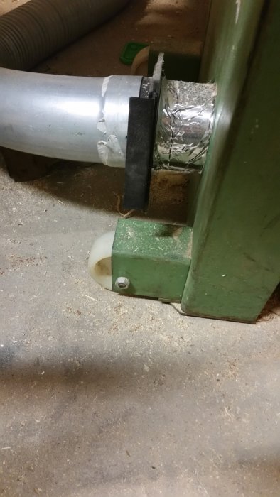Hjul fäst vid grön maskin, visar praktisk användning och installation.