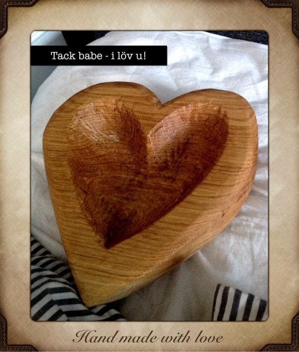 Hjärtformat träskärbräde med bränd hjärtdesign och texten "Hand made with love".