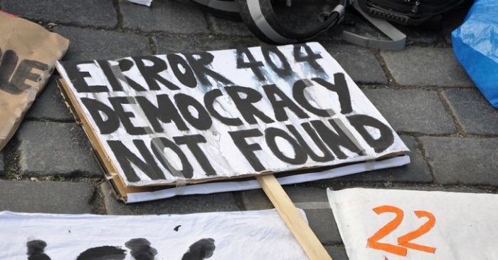 Plakat på marken med texten "Error 404 Democracy Not Found" i proteststil.