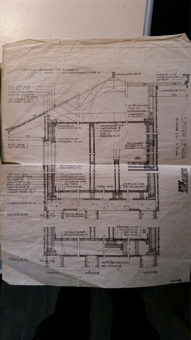 Arkitektritning av en byggnadsdetalj med måttangivelser spridda över hela pappret som hålls upp mot ett golv.