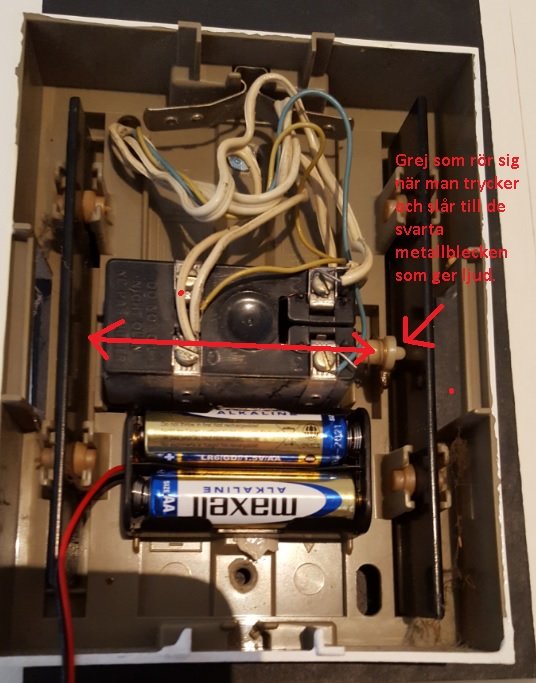 Öppen Friedland dörrklocka som visar inre mekanismen med batterier, kretsar och en metallkläpp som ger ifrån sig ljud.