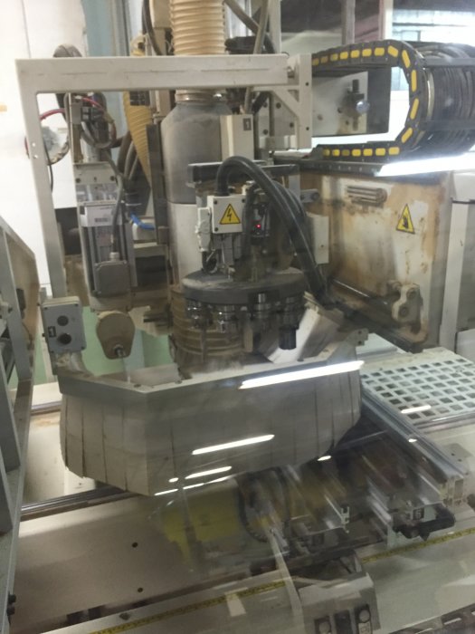 Maskinbearbetning av melaminbelagd spånskiva i ett snickeri.