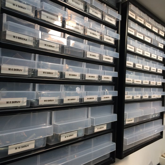 Vägg med uppmärkta förvaringslådor för skruvar och brickor i olika storlekar.