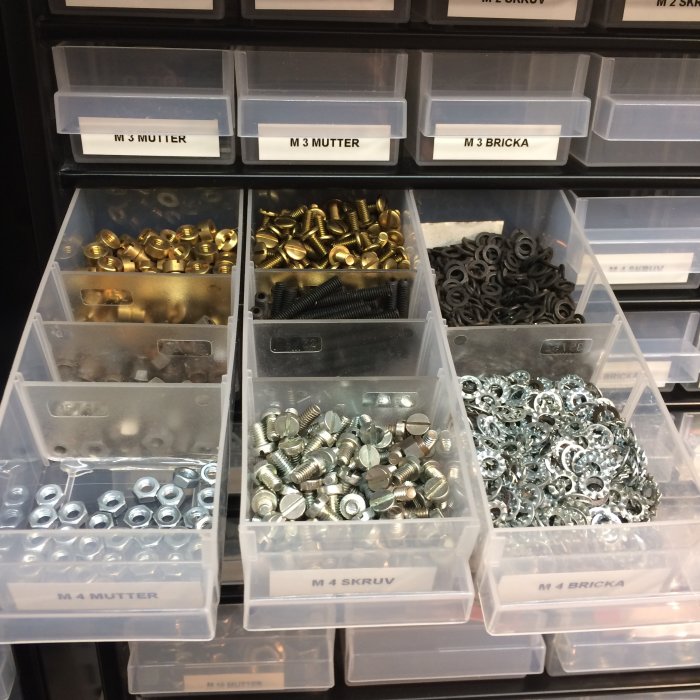 Organiserade skruvar och muttrar i märkta fack enligt storlek med skiljeväggar.