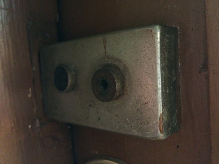 Smutsigt eluttag i hörnet av ett rum med släta ytor och synlig skada där installationen börjat.