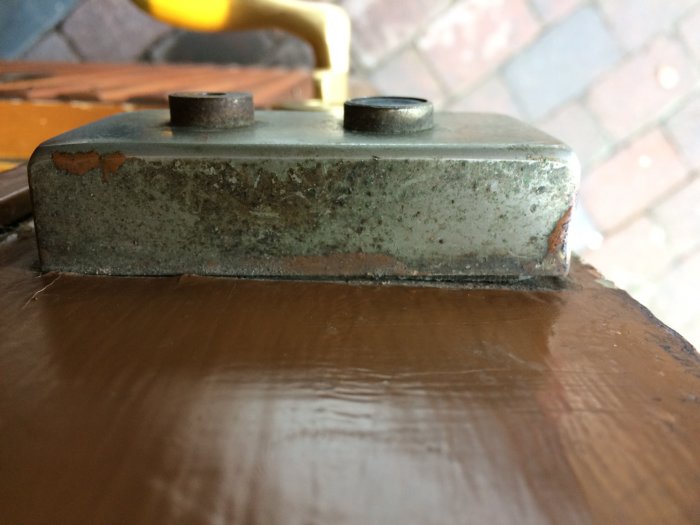 Slitet skär på verktyg med synlig rost och färgavskalning, mot en slät yta.