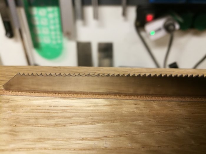 Närbild av handsåg med nyligen filade tänder som visar en jämn och spetsig tandprofil.
