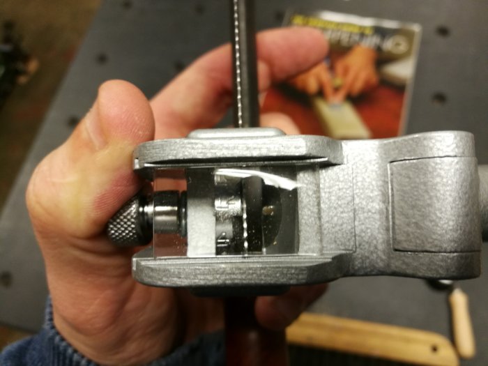 Närbild på en hand som håller en Somax skränktång, använd för att justera tänder på en såg.