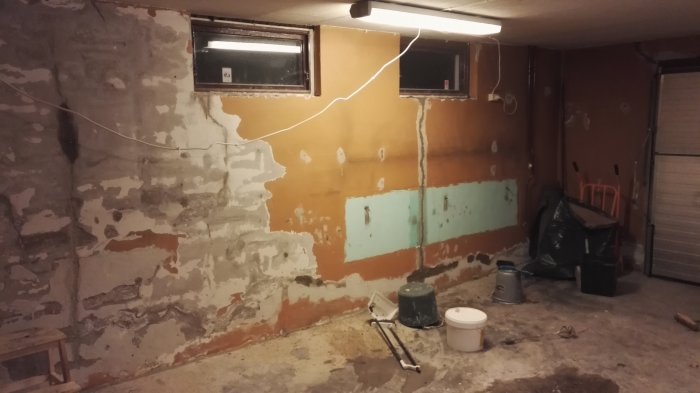 Tomt garage med spacklade och hackade väggar redo för vidare renovering.