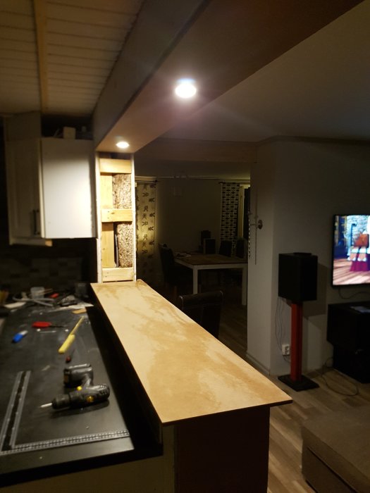 Delvis installerad belysning i en MDF-smyg med byggverktyg och material synligt i ett under renovering befintligt rum.