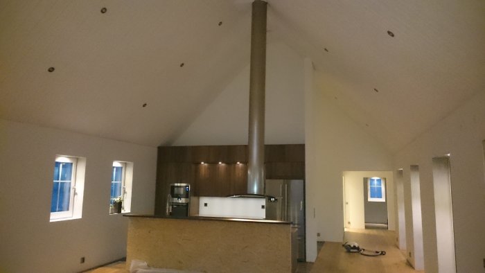 Kök under renovering med oskyddad köksö, köksfläkt, inbyggd belysning och Sharp kylskåp.