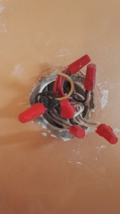 Elkablar och skarvdon i en öppen väggdosa som ska användas för belysning i ett garage.