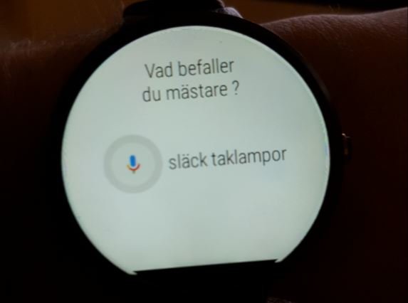 Smartklocka som visar röstkommando "släck taklampor" på en vit bakgrund med texten "Vad befaller du mästare?