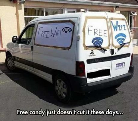 Vit skåpbil med texten "FREE WiFI" på sidan och WiFi-symboler på bakrutorna, skämtsamt erbjudande av gratis WiFi.