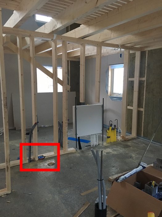 Renoveringsarbete med öppna avloppsrör i en oavslutad innervägg i tvättstuga.