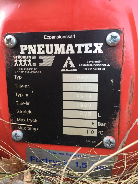 Röd expansionskärl för PNEUMATEX med tekniska specifikationer, utomhus nära marken.