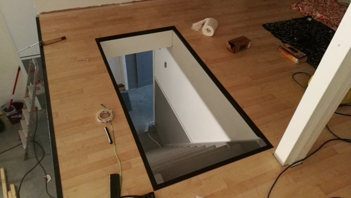 Trappöppning med kant förstärkt av svartmålat 30x30 vinkeljärn, renoveringsmaterial syns runtomkring.