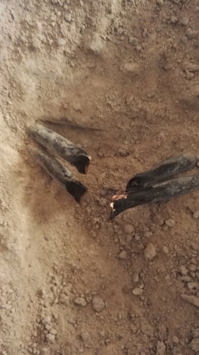 Två skadade rör i marken med smutsigt innehåll som påminner om blandning av spolarvätska och diskmedel.