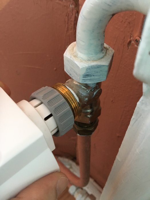 Termostat som inte passar på radiatorventil med vita plastflänsar som tar i mässingsmuttern.