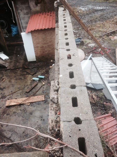 Befintlig mur av lecablock i en rivningsmiljö, redo för att höjas med fler block för ett byggprojekt.