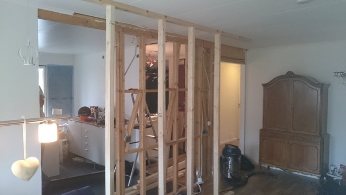 Träregelverk för en vägg i en renovering av ett inomhusutrymme med befintlig inredning.